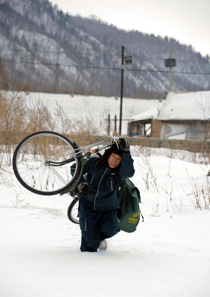 5.张振超扛着自行车走过没膝深的雪地。.jpg