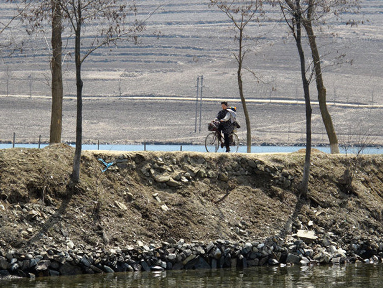 乡间小道骑着自行车的朝鲜妇女。_副本.jpg