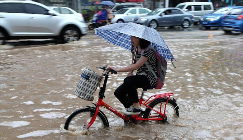 5月15日，暴雨袭击湖南省永州市，行人骑自行车在水中行进。新华社发（陶旭日 摄）_副本.jpg
